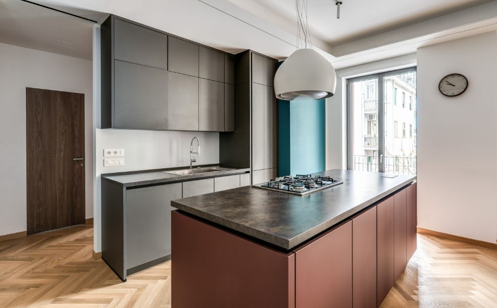 La cucina è un esempio di design minimalista e accurato, realizzata con un’isola multifunzione illuminata dalla grande finestra in alluminio Futural OC di Oknoplast
