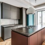 La cucina è un esempio di design minimalista e accurato, realizzata con un’isola multifunzione illuminata dalla grande finestra in alluminio Futural OC di Oknoplast