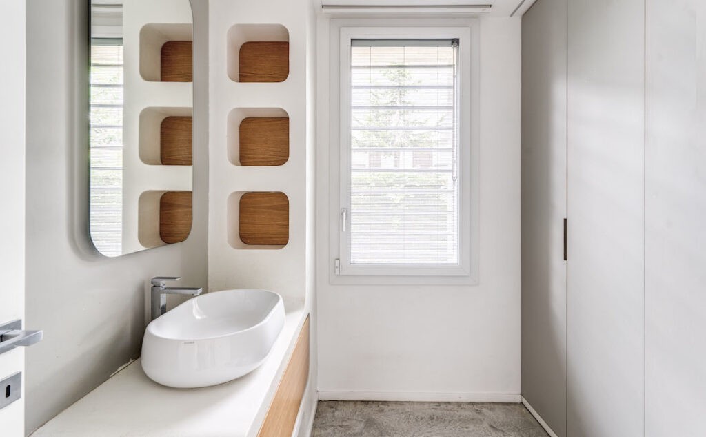 Bagno con finestra in PVC Squareline di Oknoplast con veneziane interne al vetro
