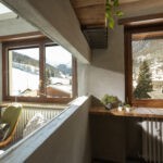 La luce del sole filtra in abbondanza dalla finestra Prolux Evolution di Oknoplast del soggiorno e arriva in cucina grazie al pratico inserimento di un pannello in vetro che unisce estetica e funzionalità