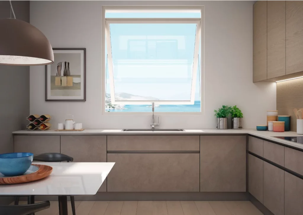 Cucina moderna con finestra a vasistas che offre una vista panoramica sul mare e armadietti minimalisti grigi.
