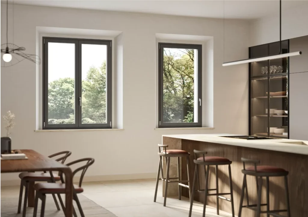 Cucina moderna luminosa con due finestre a battente con vista sul verde del giardino esterno.