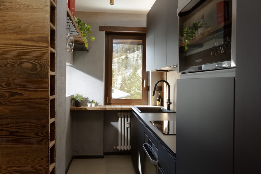 La finestra Prolux Evolution di Oknoplast posta sopra il piano della cucina incornicia il paesaggio e dona luce e comfort all’ambiente