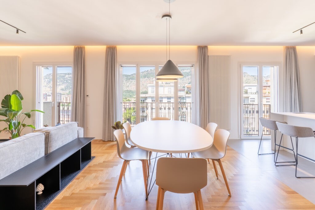 La zona living è arredata in stile minimalista e inondata di luce grazie alle tre ampie porte-finestre Prolux Evolution di Oknoplast